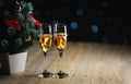 Two Glasses of Champagne Beside Small Christmas Tree Dark Glow L Royalty Free Stock Photo