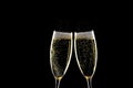 Two glasses of champagne with spray above over black background Royalty Free Stock Photo