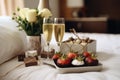 Two glasses of champagne and strawberries on the bed in the hotel room Royalty Free Stock Photo