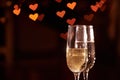 Two glasses of champagne, which stand on a black background with a beautiful bokeh, glasses against the background