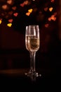 Two glasses of champagne, which stand on a black background with a beautiful bokeh, glasses against the background