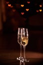 Two glasses of champagne, which stand on a black background with a beautiful bokeh, glasses against the background