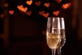 Two glasses of champagne, which stand on a black background with a beautiful bokeh, glasses against the background