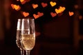 Two glasses of champagne, which stand on a black background with a beautiful bokeh, glasses against the background