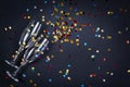 Two glasses of champagne wine with golden decoration of confetti on black background. Celebration composition for festive or party Royalty Free Stock Photo