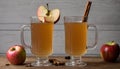 Two glasses of cider with apples and cinnamon sticks