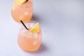 Two Glasses of Cocktail with Grapefruit and Lemon Citrus Drink or Lemonade with Ice Cubes and Straw Blue Background Copy Space Royalty Free Stock Photo