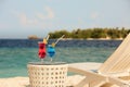 Two glasses with cocktails on table near beach bench or deck chair with blue ocean and white sand on background Royalty Free Stock Photo