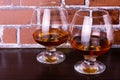 Two glasses with cognac on a brick wall background. Royalty Free Stock Photo