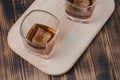 Two Glasses of cognac with ice cubes on a wooden table/Two Glasses of cognac with ice cubes on a wooden table. Top view Royalty Free Stock Photo
