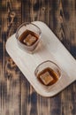 Two Glasses of cognac with ice cubes on a wooden table/Two Glasses of cognac with ice cubes on a wooden table. Top view Royalty Free Stock Photo