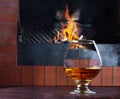 Two glasses of cognac on old brick fireplace Royalty Free Stock Photo