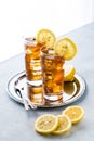 Two glasses of cold ice tea and lemon slices on a metal tray against a bright background. Royalty Free Stock Photo