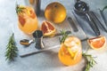 Two glasses of cold lemonade of fresh grapefruit juice, alcohol and ice cubes decorated slice citrus and twig rosemary Royalty Free Stock Photo