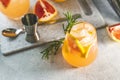 Two glasses of cold lemonade of fresh grapefruit juice, alcohol and ice cubes decorated slice citrus and twig rosemary Royalty Free Stock Photo