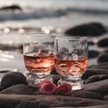 Two glasses of cold rose wine with ice cubes on sandy beach on a sunny day, close up. Holiday concept. Hot summer time at the sea Royalty Free Stock Photo