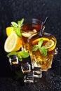 Two glasses with cold traditional iced tea with lemon, mint leaves and ice cubes Royalty Free Stock Photo