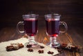 Two glasses,cup of red hot drink.Mulled wine on wooden background with christmas spices,orange slice,anise and cinnamon Royalty Free Stock Photo
