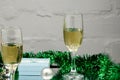 Two glasses of delicious champagne close up on a brown Christmas toy red, green, and gold color