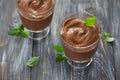 Two glasses with delicious vegan chocolate mousse made of banana with cocoa and mint