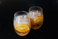 Two glasses. Two drinks with orange ice tea. Oranges slices