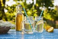 Two glasses of elderflower lemonade with bottle of syrup