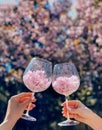 Two glasses filled with flowers on blossoming tree background