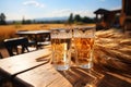 Two glasses of fresh beer on a wooden table on sunny summer day. Beer on a background of wheat field. Drinking alcoholic beverage Royalty Free Stock Photo