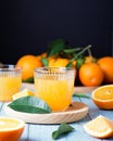 Two glasses of fresh juice, fruit squeezer and ripe fresh oranges on blue wooden table top, fresh orange juice making, top view Royalty Free Stock Photo