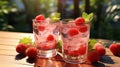 Two glasses with raspberries and ice on wooden table at garden Royalty Free Stock Photo
