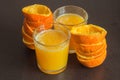 Two glasses of freshly squeezed orange juice with the fruit peels next to them on an elegant dark wooden table. Royalty Free Stock Photo