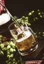 Two glasses of german light beer, beer poured into mug, dark bar counter, selective focus Royalty Free Stock Photo