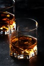 Two glasses of golden scotch whiskey on dark old bar table background, selective focus