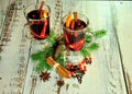 Two glasses of hot wine with slices of fruit and spices, stand in the center of the composition of fir branches and cones on a Royalty Free Stock Photo