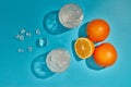 Two glasses with ice and oranges on blue background with shadow. Top view. Cocktail. Fresh orange juice Royalty Free Stock Photo