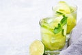 Two glasses of iced green matcha tea with lime, ice, fresh mint and grey napkin on light grey background Royalty Free Stock Photo