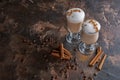 Two glasses of latte on a wooden rustic table with coffee beans and cinnamon Royalty Free Stock Photo