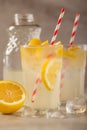 Two glasses of lemonade with lemons and lime and straw, a cool drink and summer mood, with ice