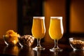 Two glasses with light beer and foam on wooden bar counter in interior of pub, pistachios, crackers and nuts in glass