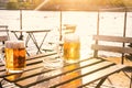 Two glasses of light beer with foam on a wooden table.On a boat. Garden party. Natural background. Alcohol. Draft beer. Landscape, Royalty Free Stock Photo