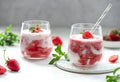 Two glasses of milkshake with fresh strawberries and mint.