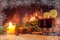 Two glasses with mulled wine, a candle, fir branches with decorations on a wooden table against the background of a Royalty Free Stock Photo