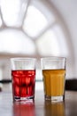 Two glasses with orange juice and pomegranate juice are on the table in a cafe. healthy drinks, smoothies, citro and lemonade clos Royalty Free Stock Photo