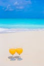 Two glasses of orange juice on tropical white beach Royalty Free Stock Photo