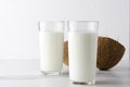 Two glasses of organic coconut milk kefir on white clean table against white