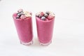 Two glasses of pink fruit smoothies milkshake or smoothie or cocktail on a white wooden background. Healthy juicy Royalty Free Stock Photo