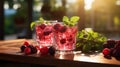 Two glasses with raspberries and blackberries and ice on wooden table at summer garden Royalty Free Stock Photo