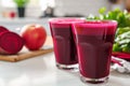 Two glasses of red beet juice with fresh apples in a modern kitchen Royalty Free Stock Photo