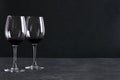 Two glasses of red thick and heavy, mouthfeel wine on the rustic surface agaisnt black background