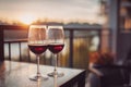 Two glasses of red wine on balcony table at sunset with scenic view Royalty Free Stock Photo